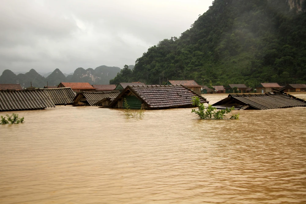 Nhiều ngôi nhà tại xã Minh Hóa (Quảng Bình) bị ngập đến tận nóc nhà. (Ảnh: Văn Tý/TTXVN)
