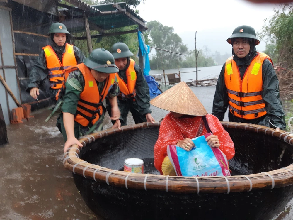 Cán bộ chiến sỹ Đồn Biên phòng Vinh Hiền di dời dân vùng thấp trũng lên vùng cao. (Ảnh: TTXVN phát)