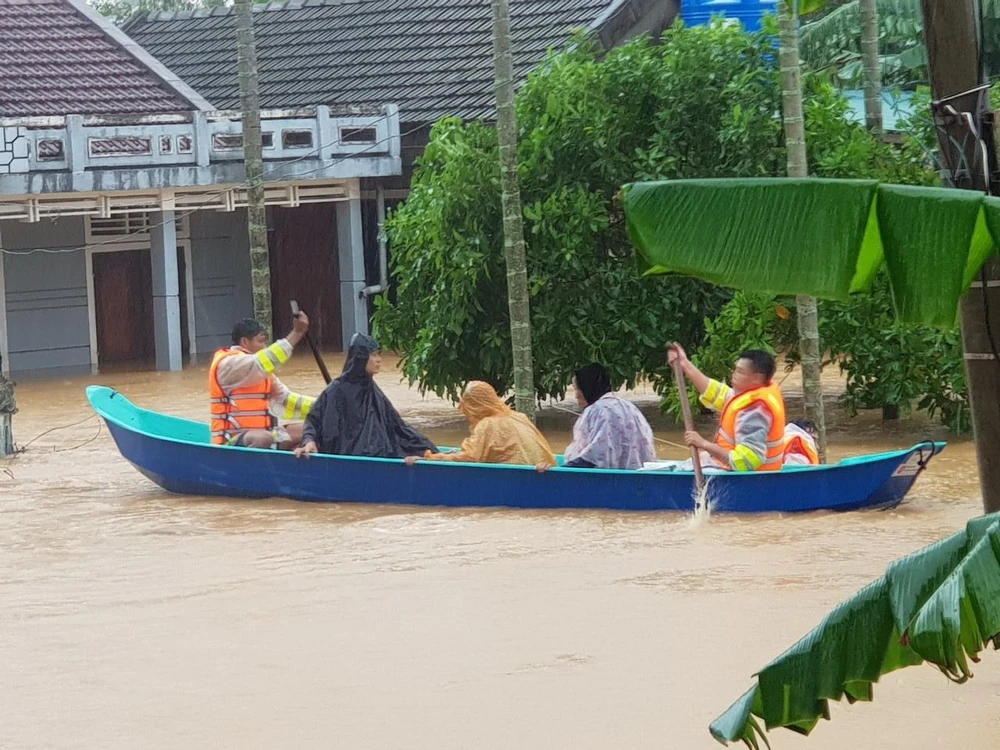 Di chuyển người dân ra khỏi khu vực ngập lũ tại huyện Cam Lộ, Quảng Trị. (Ảnh: Thanh Thủy/TTXVN)