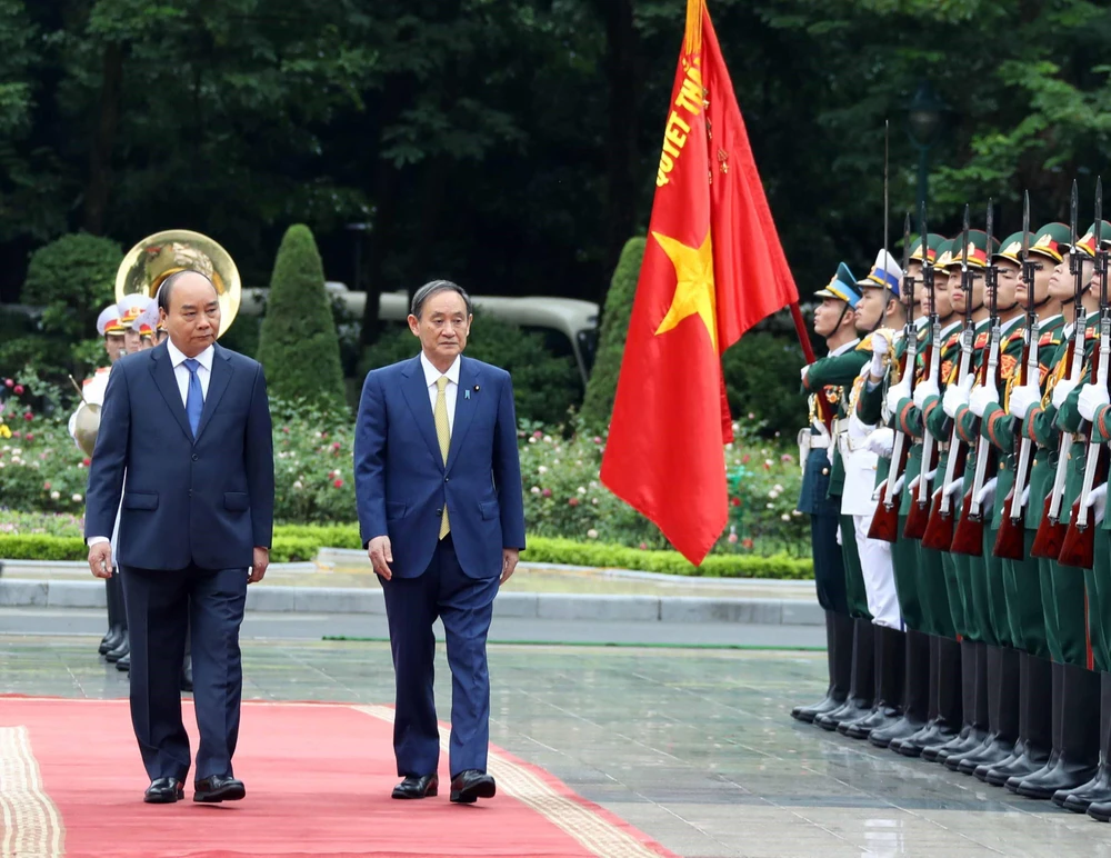 Thủ tướng Nguyễn Xuân Phúc và Thủ tướng Nhật Bản Suga Yoshihide duyệt đội danh dự Quân đội Nhân dân Việt Nam. (Ảnh: Thống Nhất/TTXVN)