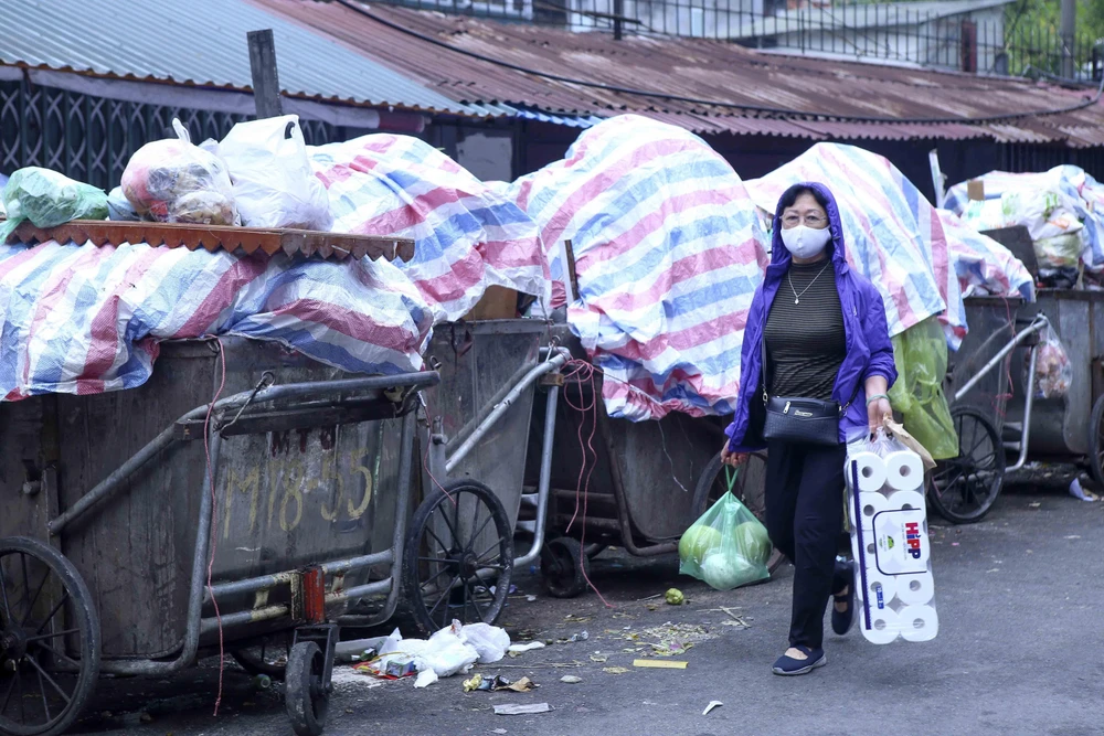 Các xe rác được phủ bạt tại khu tập thể Nam Đồng (Ảnh chụp sáng 26/10). (Ảnh: Tuấn Đức/TTXVN)