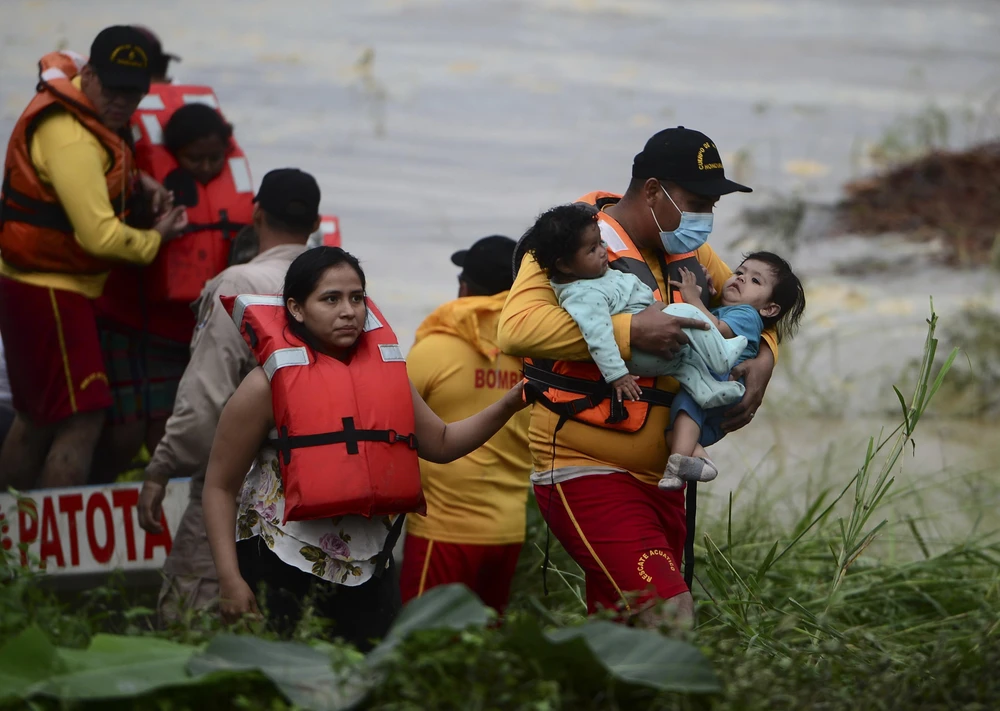 Sơ tán người dân khỏi các khu vực ngập lụt do mưa lớn sau bão Eta tại El Progreso, Honduras. (Ảnh: AFP/TTXVN)
