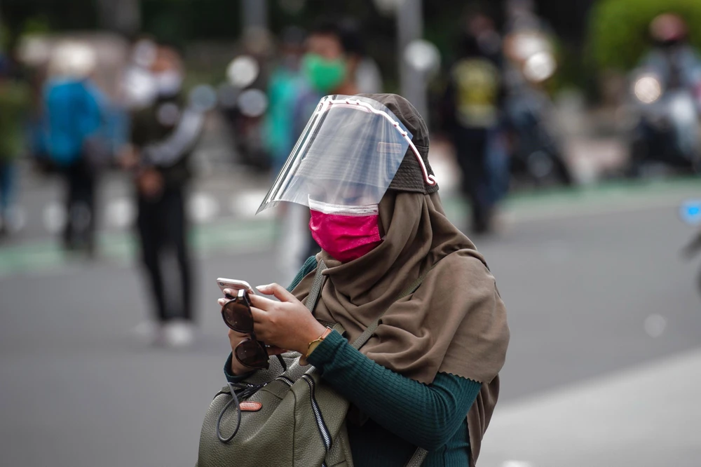 Người dân đeo khẩu trang phòng lây nhiễm COVID-19 tại Jakarta, Indonesia. (Ảnh: THX/ TTXVN)