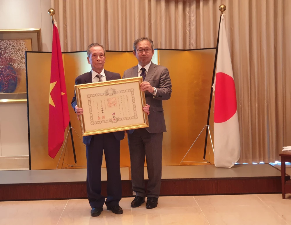 Đại sứ Nhật Bản tại Việt Nam trao Huân chương mặt trời mọc tia sáng vàng và nơ thắt hoa hồng cho Phó Giáo sư-Tiến sỹ Trần Sơn. (Ảnh: Phương Anh/TTXVN)