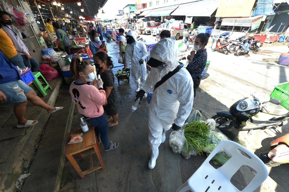 Phun thuốc khử trùng nhằm ngặn chặn sự lây lan của COVID-19 tại một khu chợ ở tỉnh Samut Sakhon, Thái Lan. (Ảnh: THX/TTXVN)