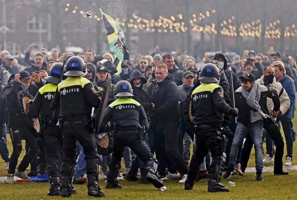 Cảnh sát chống bạo động giải tán người biểu tình tại Amsterdam, Hà Lan ngày 17/1. (Ảnh: AFP/TTXVN)