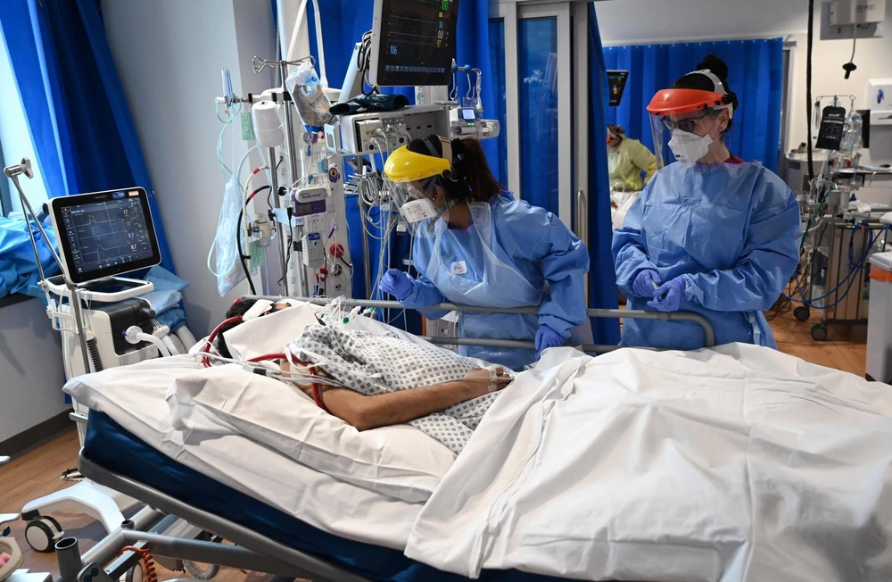 Nhân viên y tế điều trị cho bệnh nhân COVID-19 tại bệnh viện ở Cambridge, Anh. (Ảnh: AFP/TTXVN)
