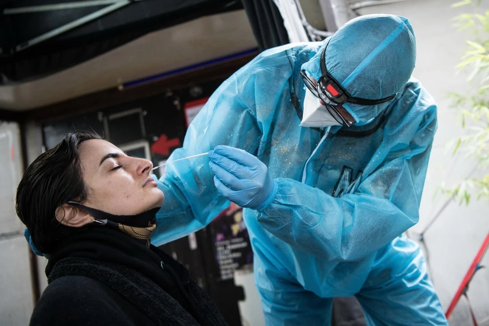 Nhân viên y tế lấy mẫu xét nghiệm COVID-19 cho người dân tại Berlin, Đức. (Ảnh: AFP/TTXVN)