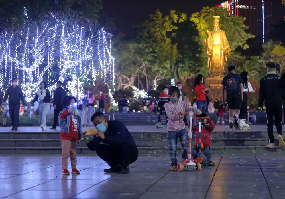 Người dân vui chơi đón năm mới tại khu vực Tượng đài Lý Thái Tổ. (Ảnh: Hoàng Hiếu/TTXVN)