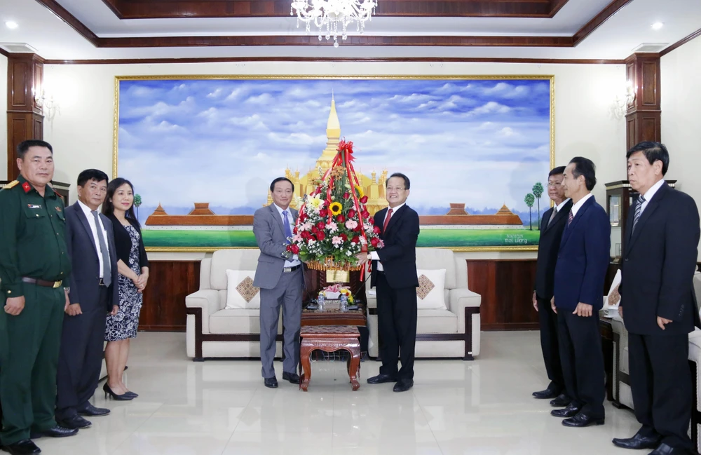 Đại sứ Việt Nam tại Lào Nguyễn Bá Hùng trao lẵnh hoa chúc mừng 66 năm Ngày thành lập Đảng NDCM Lào. (Ảnh: Phạm Kiên/TTXVN)
