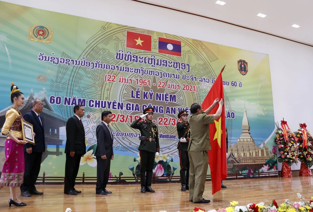 Thượng tướng Vilay Lakhamphong, Bộ trưởng Bộ Công an Lào gắn Huân chương Itsala Hạng II của Đảng Nhà nước Lào cho Cơ quan Đại diện Bộ Công Việt Nam tại Lào. (Ảnh: Phạm Kiên/TTXVN)