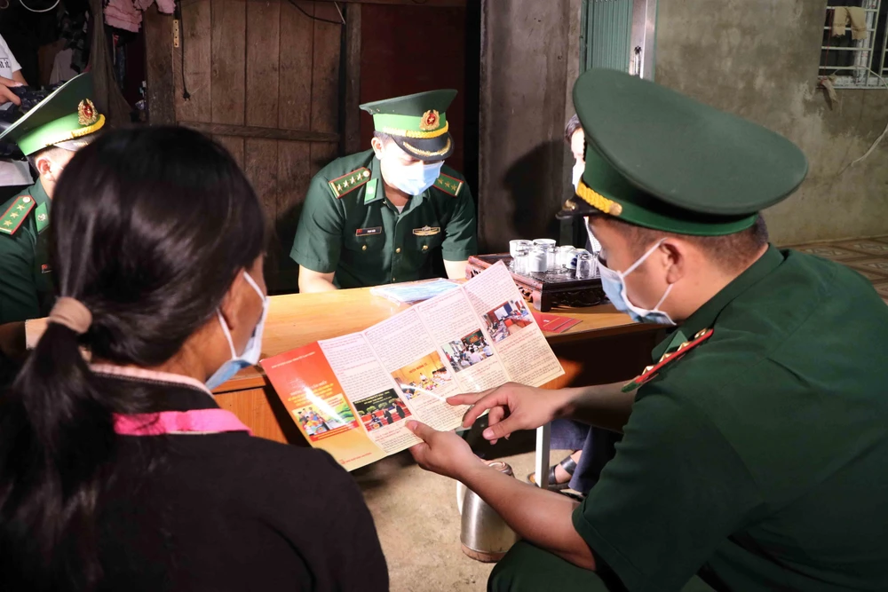 Cán bộ chiến sỹ Đồn Biên phòng Huổi Luông đến từng nhà dân tuyên truyền về bầu cử. (Ảnh: Nguyễn Oanh/TTXVN)