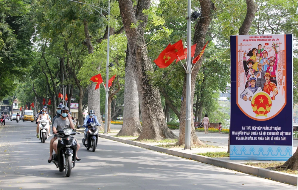 Pano, cờ Tổ quốc rực rỡ trên phố Lê Thái Tổ, quận Hoàn Kiếm (chụp sáng 15/5/2021). (Ảnh: Hoàng Hiếu/TTXVN)