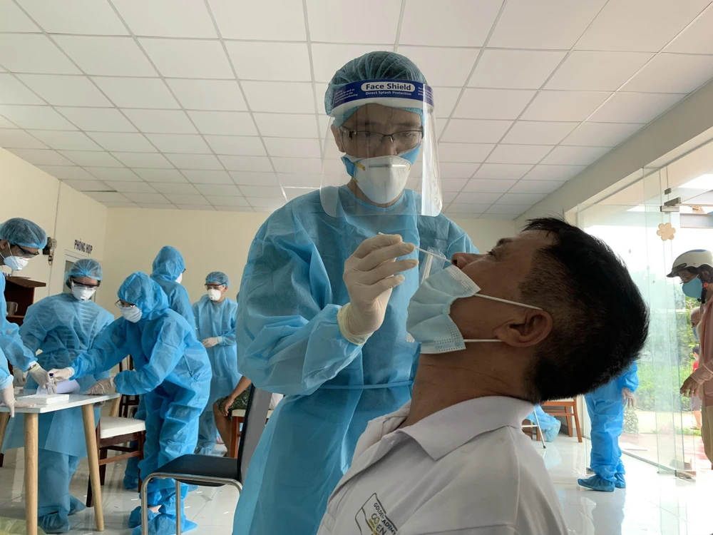 Nhân viên y tế lấy mẫu xét nghiệm COVID-19 cho người dân tại Thành phố Hồ Chí Minh. (Ảnh: TTXVN phát)