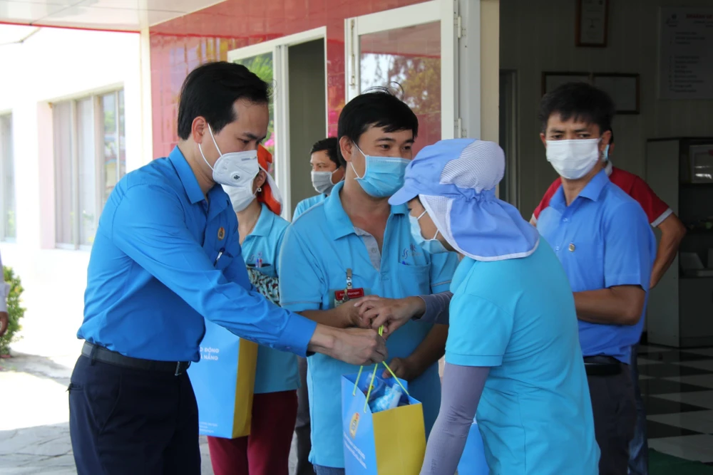 Chủ tịch Liên đoàn Lao động thành phố Đà Nẵng Nguyễn Duy Minh trao quà cho đoàn viên, người lao động có hoàn cảnh khó khăn do dịch COVID-19. (Ảnh: TTXVN phát)
