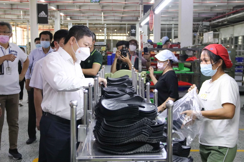 Phó Chủ tịch Dương Anh Đức thăm hỏi công nhân tại các chuyền sản xuất của Công ty trách nhiệm hữu hạn Pouyuen Việt Nam (quận Bình Tân). (Ảnh: Thanh Vũ/TTXVN)