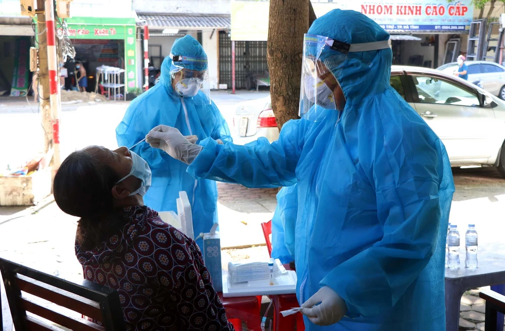 Lực lượng y tế lấy mẫu xét nghiệm ở Tổ dân phố Tân Quý, phường Thạch Quý, thành phố Hà Tĩnh. (Ảnh: Công Tường/TTXVN)