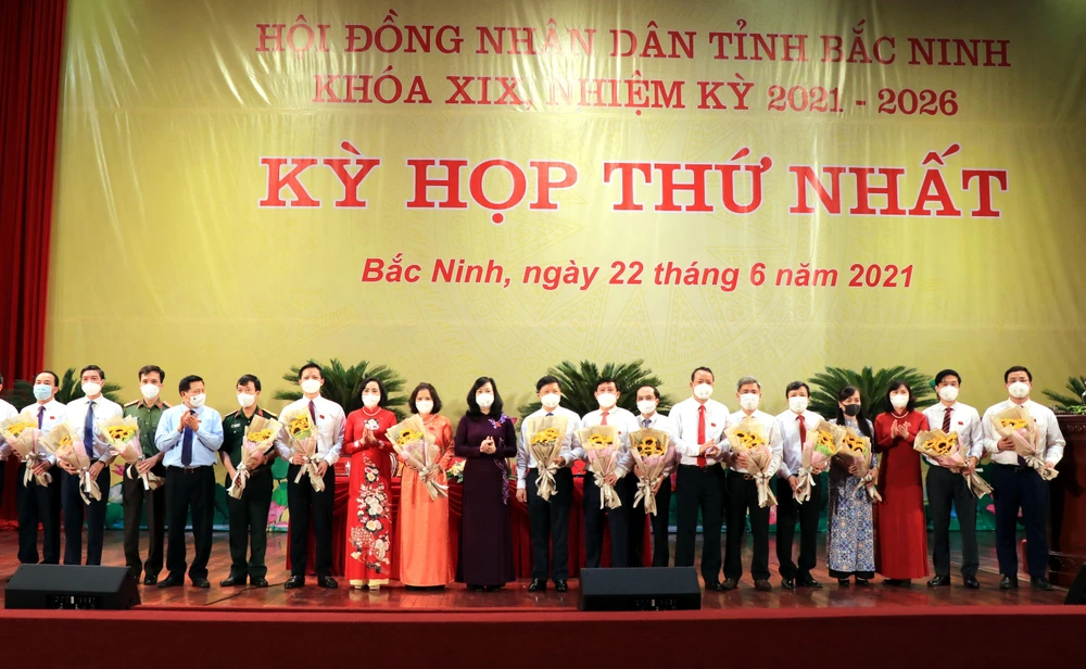 Lãnh đạo tỉnh Bắc Ninh tặng hoa các đồng chí được bầu giữ các chức danh chủ chốt của UBND tỉnh khóa XIX. (Ảnh: Đinh Văn Nhiều/TTXVN)