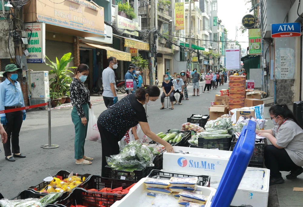 Người dân mua hàng hóa thiết yếu tại một “Phiên chợ lưu động” được tổ chức tại khu phố 3, phường 2, Quận 3, Thành phố Hồ Chí Minh. (Ảnh: Quang Châu/TTXVN)