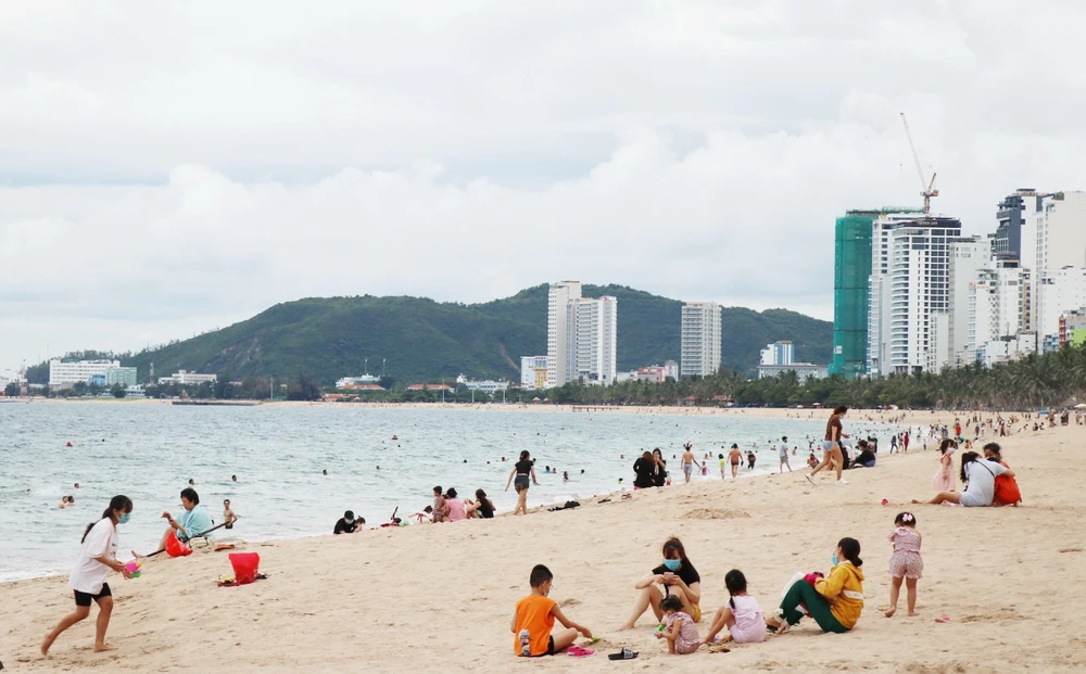 Bãi biển Nha Trang đã nhộn nhịp trở lại trong ngày đầu tiên cho phép tắm biển. (Ảnh: Tiên Minh/TTXVN)
