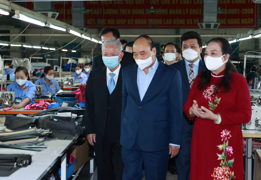 Chủ tịch nước Nguyễn Xuân Phúc thăm Công ty TNHH sản xuất dịch vụ thương mại sản phẩm da LADODA, do ông Đinh Quang Bào, 83 tuổi là đại diện pháp luật. (Ảnh: Thống Nhất/TTXVN)