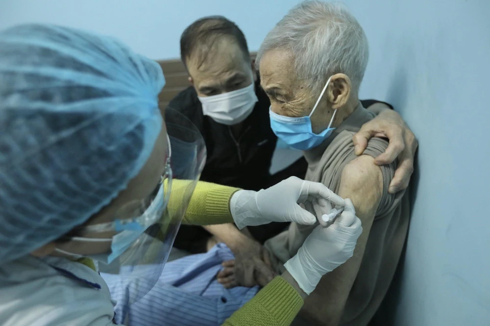 Nhân viên y tế tiêm vaccine phòng COVID-19 cho người cao tuổi phường Đồng Tâm (quận Hai Bà Trưng). (Ảnh: Minh Quyết/TTXVN)