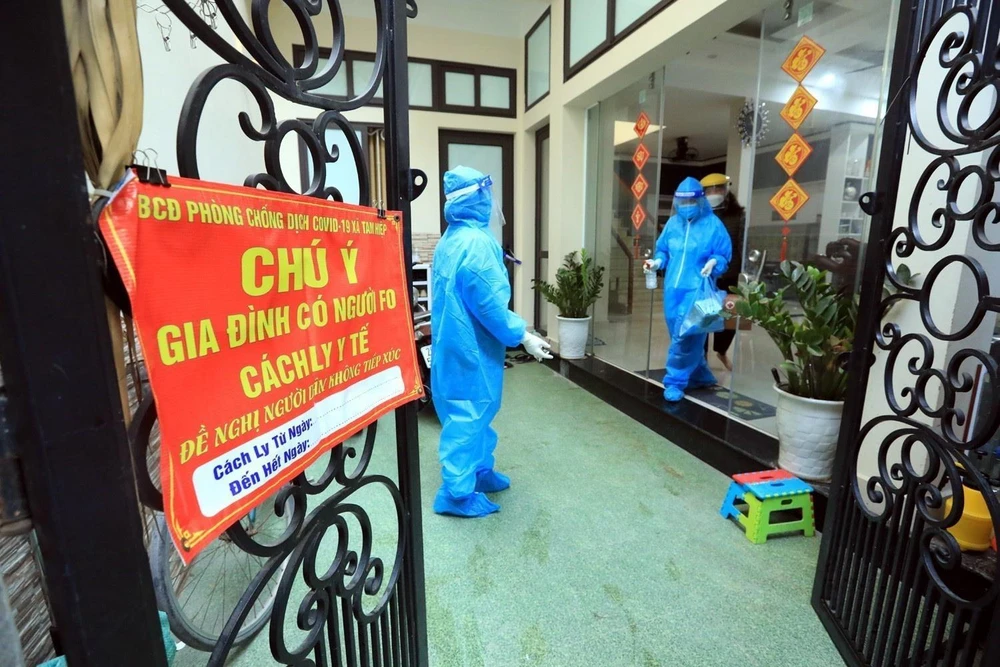 Nhân viên y tế ghi thông tin trường hợp F0 đang điều trị tại nhà tại Xóm 2, xã Tam Hiệp, huyện Thanh Trì. (Ảnh: Tuấn Anh/TTXVN)