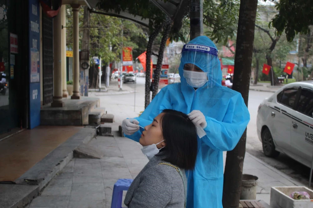 Nhân viên y tế lấy mẫu xét nghiệm COVID-19 cho người dân thành phố Thanh Hóa hôm 5/2. (Ảnh: Nguyễn Nam/TTXVN)