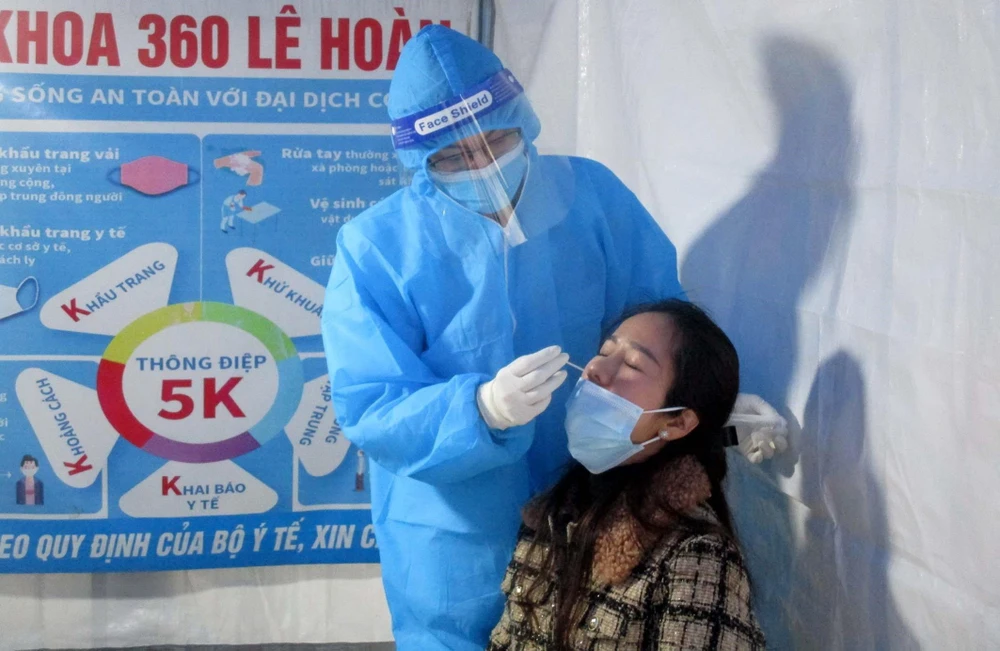 Nhân viên y tế lấy mẫu xét nghiệm tầm soát COVID-19 cho người dân thành phố Thanh Hóa. (Ảnh: Nguyễn Nam/TTXVN)