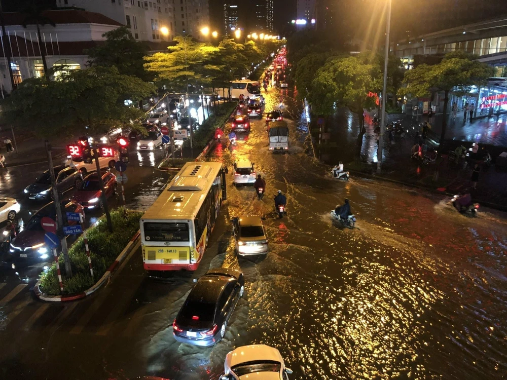 Mưa lớn gây ngập úng tại phố Đào Tấn, khiến các phương tiện lưu thông khó khăn. (Ảnh: Huy Hùng/TTXVN)