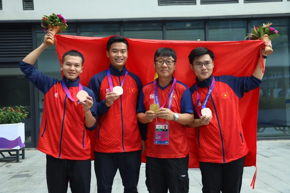 Phạm Quang Huy (thứ 2 từ trái qua) ăn mừng chiến thắng cùng các đồng đội và chuyên gia Park Chung Gun. (Ảnh: TTXVN phát) 