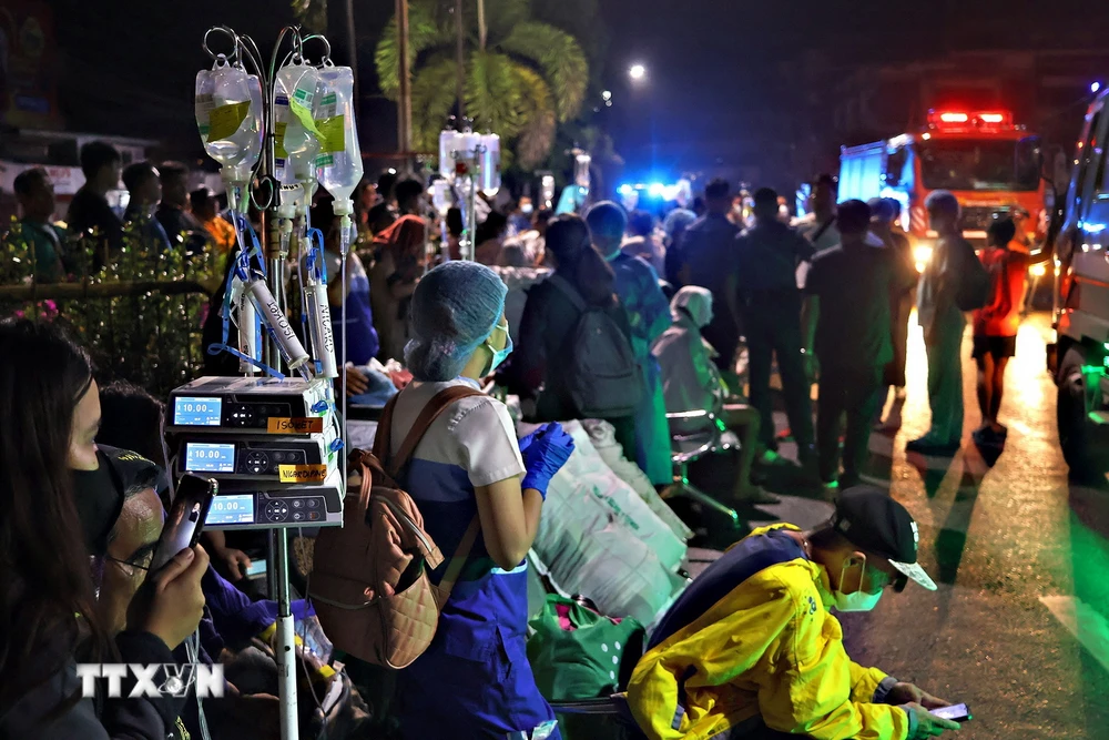 Người dân và nhân viên y tế sơ tán các bệnh nhân ra bên ngoài bệnh viện khi xảy ra động đất tại Butuan, trên đảo Mindanao, Philippines, ngày 2/12/2023. (Ảnh: AFP/TTXVN)