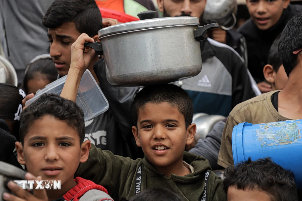 Trẻ em Palestine nhận thực phẩm cứu trợ tại thành phố Rafah, Dải Gaza ngày 19/11/2023. (Ảnh: THX/TTXVN)