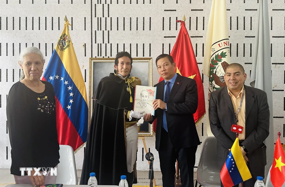 Tiến sỹ Juan Gamez trao tặng ảnh Chủ tịch Hồ Chí Minh do chính ông vẽ cho Đại sứ Việt Nam tại Venezuela Vũ Trung Mỹ. (Ảnh: TTXVN phát)