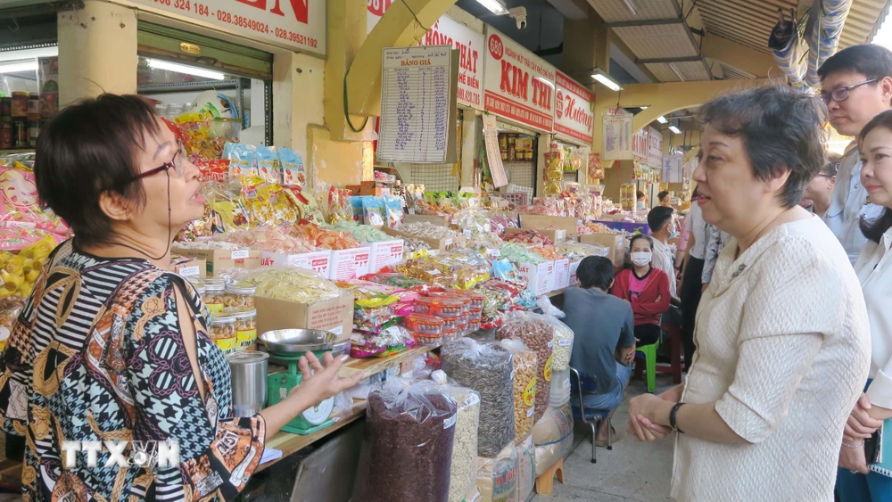Lãnh đạo Sở An toàn thực phẩm Thành phố Hồ Chí Minh trao đổi với tiểu thương chợ Bình Tây về công tác đảm bảo an toàn thực phẩm. (Ảnh: Đinh Hằng/TTXVN)