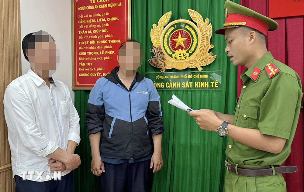 Cơ quan chức năng Công an Thành phố Hồ Chí Minh thực hiện quyết định khởi tố bị can, ra lệnh bắt tạm giam Hồ Việt Tân (trái) và Bùi Huỳnh Bá Phước (giữa). (Ảnh: TTXVN phát)