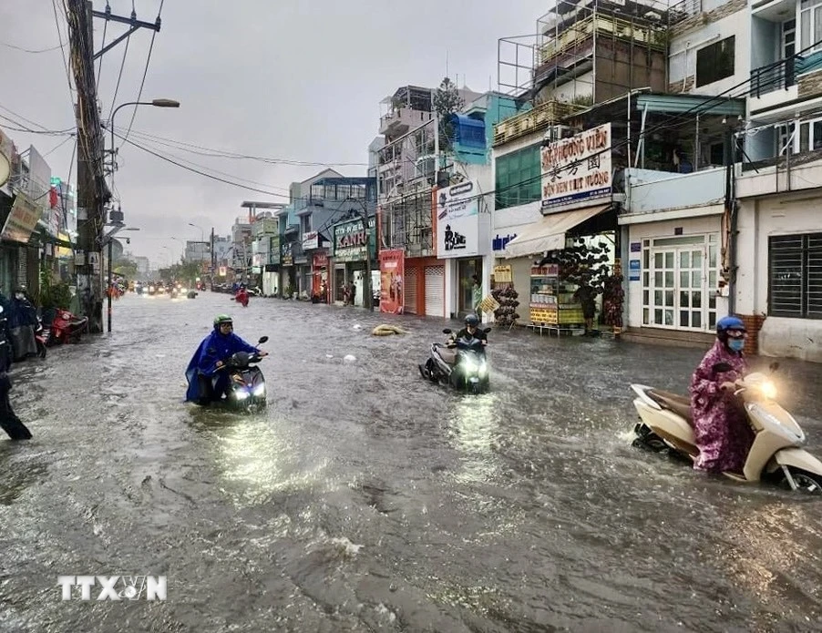 Nước ngập lút bánh xe mô tô trên đường Kha Vạn Cân (thành phố Thủ Đức, Thành phố Hồ Chí Minh). (Ảnh: Hồng Giang/TTXVN)