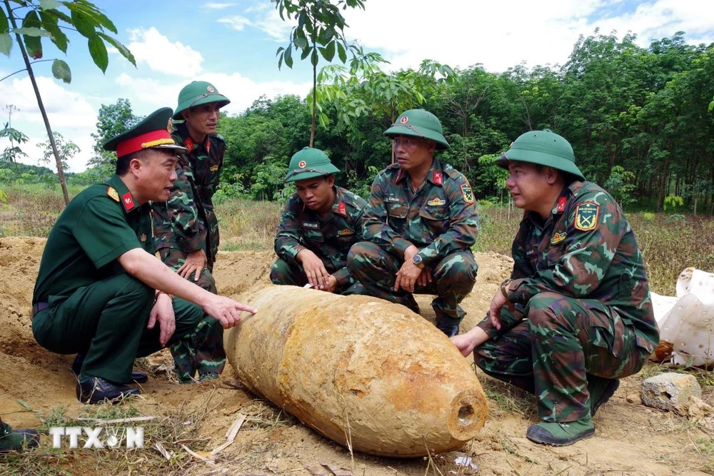 Lực lượng chức năng khảo sát, lên phương án hủy nổ quả bom. (Ảnh: TTXVN phát)