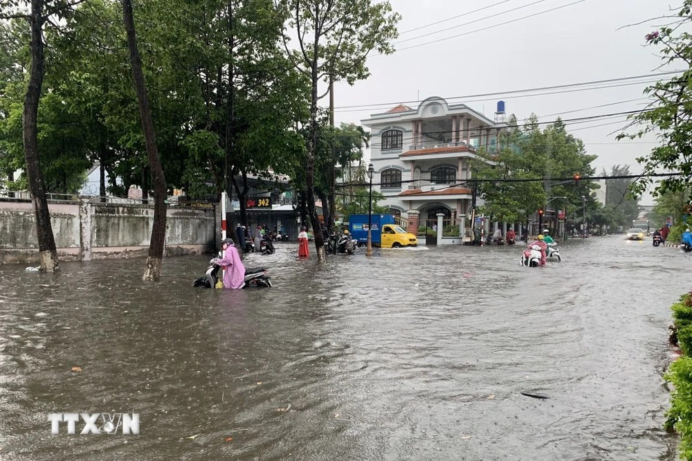 Khu vực gần ngã 4 Phạm Hùng-Lạc Hồng bị ngập sâu làm chết máy nhiều phương tiện giao thông. (Ảnh: Văn Sĩ/TTXVN)