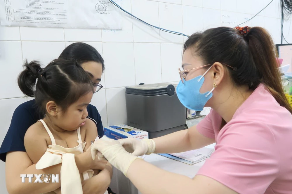 Nhân viên trạm Y tế Phường 6, Quận 8 tiêm vaccine phòng sởi cho trẻ. (Ảnh: Đinh Hằng/TTXVN)