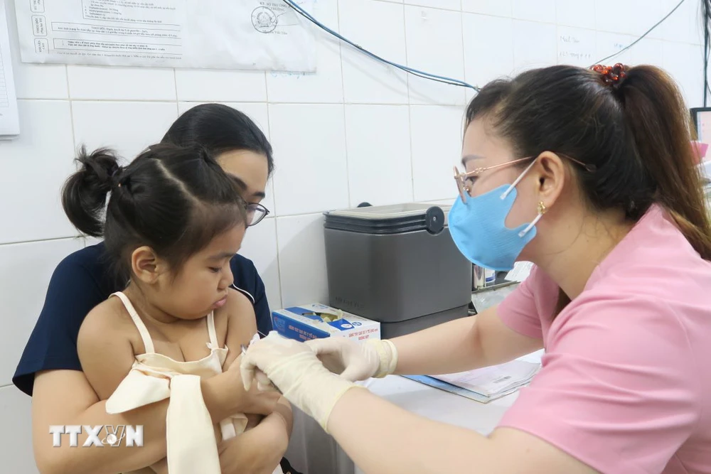 Nhân viên trạm Y tế Phường 6, Quận 8 tiêm vaccine phòng sởi cho trẻ. (Ảnh: Đinh Hằng/TTXVN)