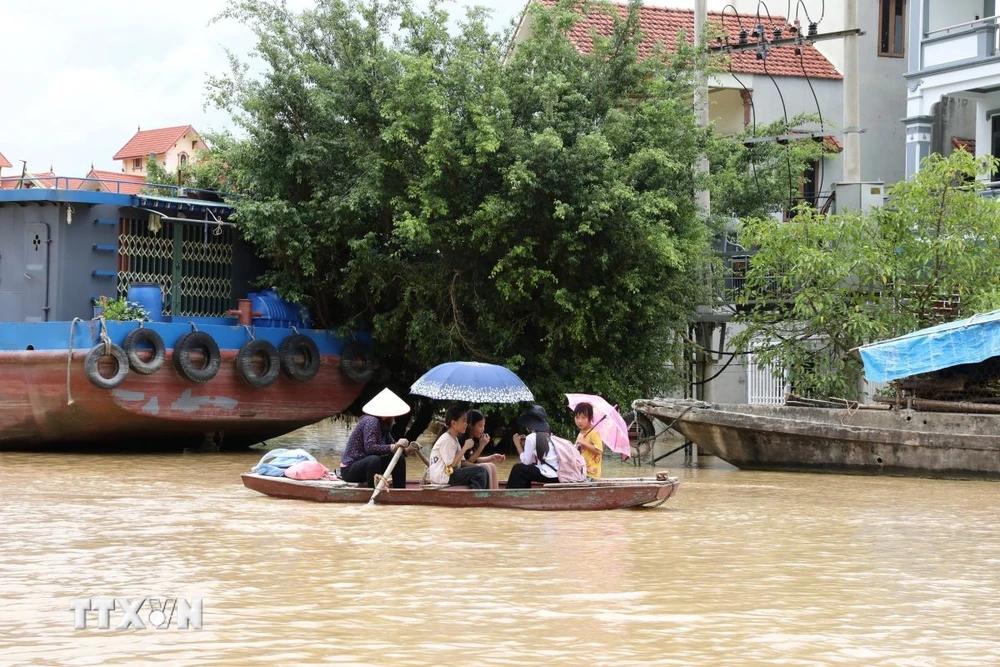 Học sinh được chở bằng thuyền đến trường học. (Ảnh: Đức Phương/TTXVN)