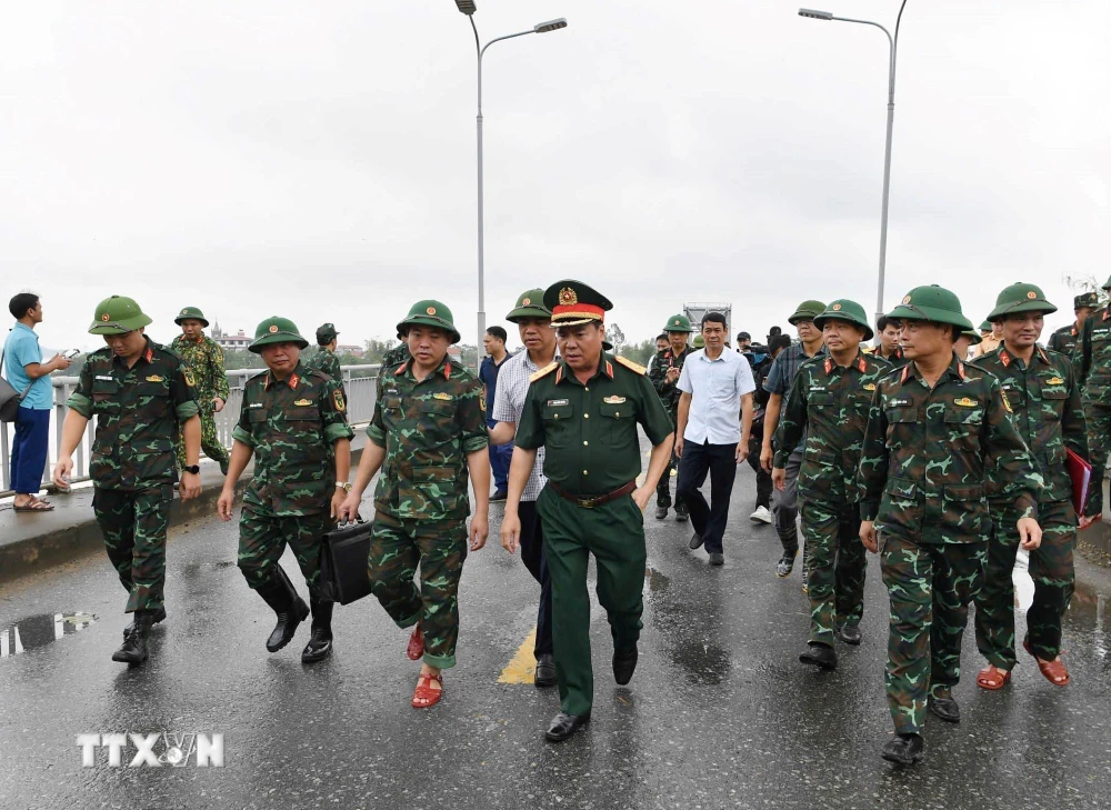 Trung tướng Phạm Đức Duyên, Bí thư Đảng ủy, Chính ủy Quân khu 2 và đại diện các đơn vị khảo sát vị trí lắp cầu phao. (Ảnh: TTXVN phát)