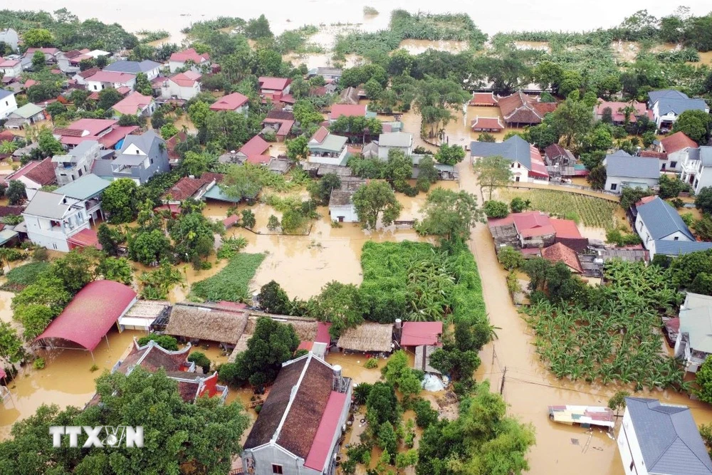 Hàng nghìn hộ dân dọc tuyến đường 32C ven theo sông Hồng thuộc các xã Tuy Lộc, Minh Tân bị nhấn chìm trong biển nước. (Ảnh: Tạ Toàn/TTXVN)