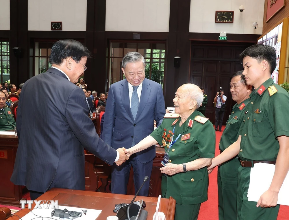 Tổng Bí thư, Chủ tịch nước Tô Lâm cùng Tổng Bí thư, Chủ tịch nước Lào Thongloun Sisoulith với Thiếu tướng Huỳnh Đắc Hương, Trưởng ban liên lạc toàn quốc Cựu quân tình nguyện và chuyên gia quân sự Việt Nam tại Lào. (Ảnh: Trí Dũng/TTXVN)