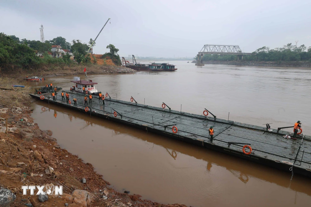 Lực lượng công binh chung sức đưa các đốt khơi đến vị trí lắp đặt. (Ảnh: An Đăng/TTXVN)