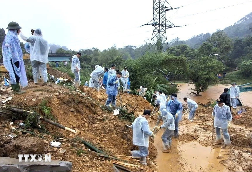 Cán bộ, chiến sỹ Công an tỉnh Hà Giang và các lực lượng chức năng nỗ lực tìm kiếm nạn nhân mất tích trong vụ sạt lở nghiêm trọng. (Ảnh: TTXVN phát)