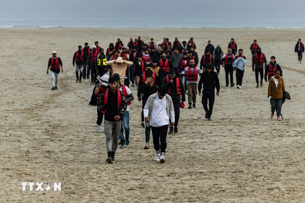 Dòng người di cư trên bờ biển Gravelines, miền Bắc Pháp. (Ảnh: AFP/TTXVN)