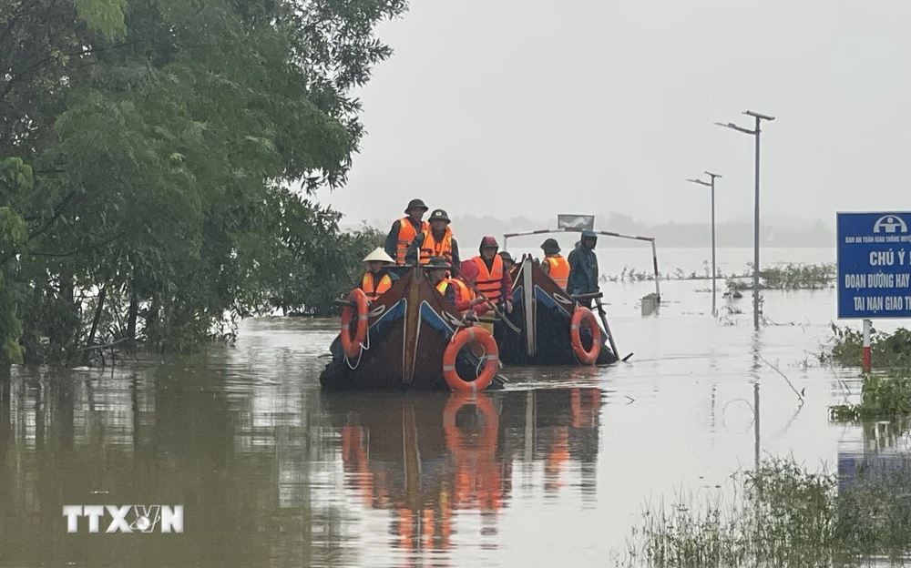 Các lực lượng chức năng di chuyển bằng thuyền hỗ trợ người dân vùng ngập lụt. (Ảnh: Thanh Thủy/TTXVN)