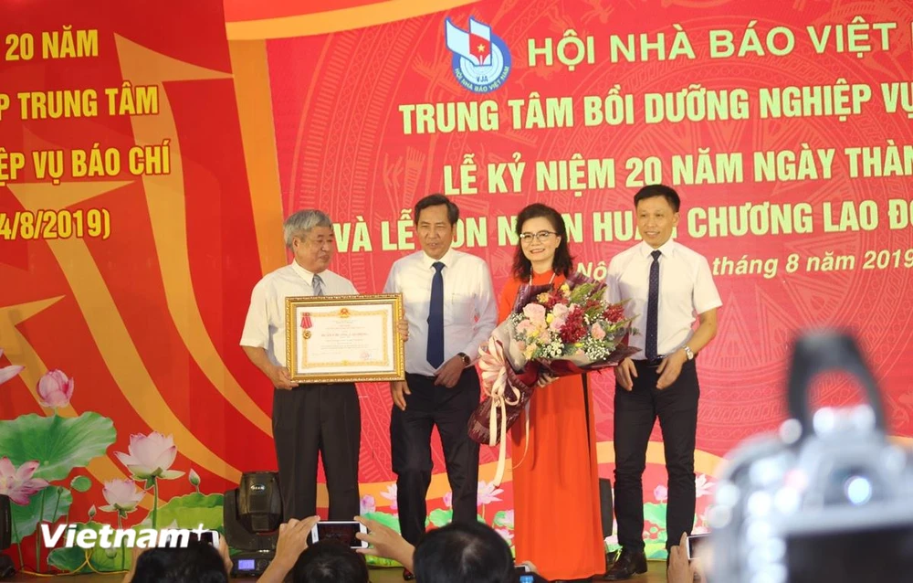 Nhà báo Thuận Hữu, Chủ tịch Hội Nhà báo Việt Nam (thứ 2 bên trái) trao tặng Huân chương Lao động hạng Nhì cho Trung tâm Bồi dưỡng nghiệp vụ báo chí. (Ảnh: H.V/Vietnam+)